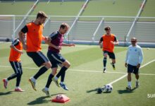Atlet sepak bola melakukan latihan plyometric dengan pelatih